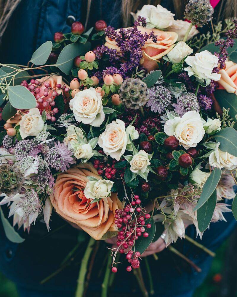 Fleuriste, bouquet en main, devant sa future boutique